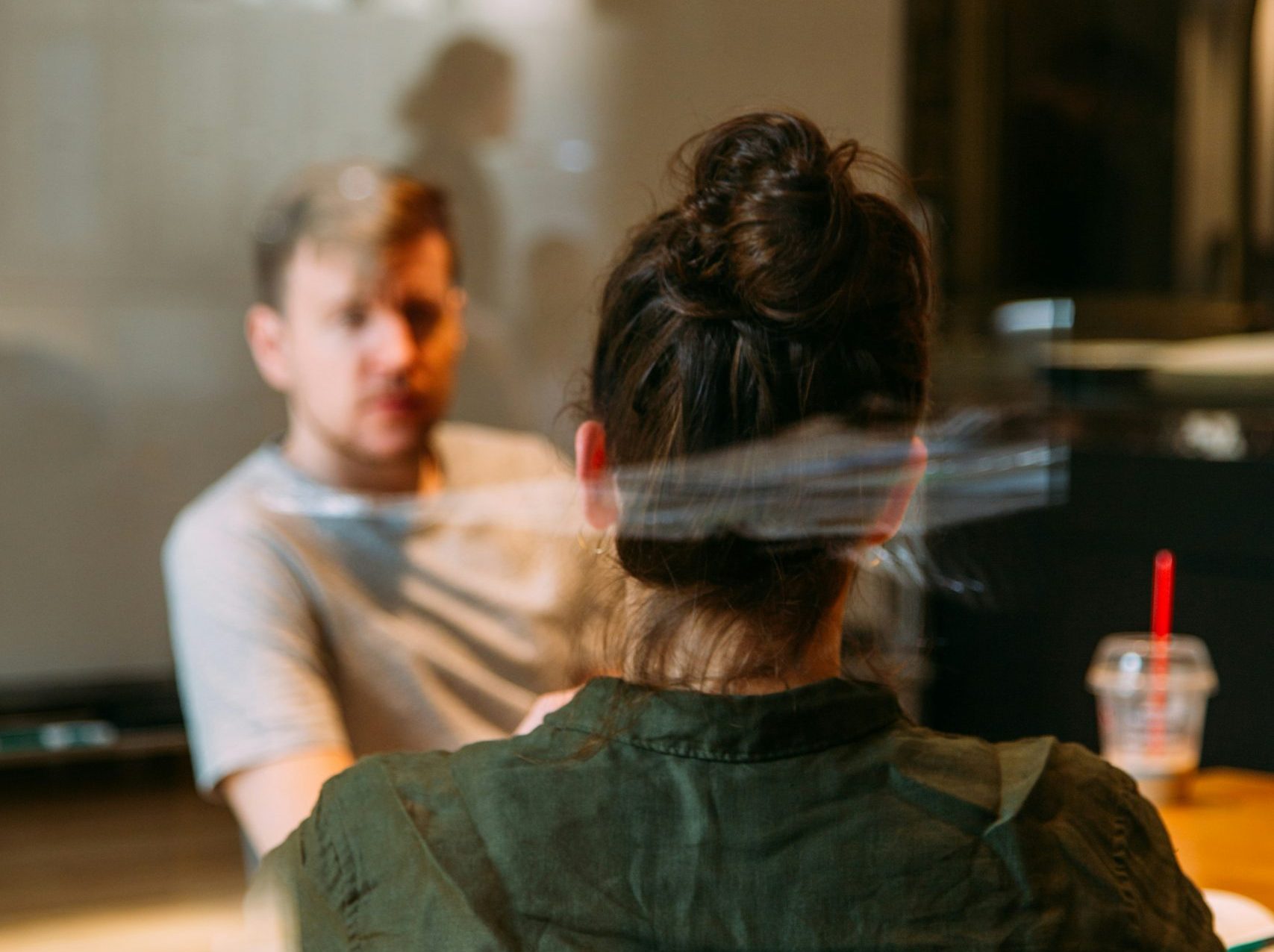 Two people sitting at a desk having a conversation.