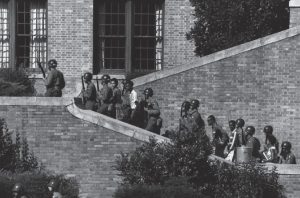 Armed people in helmets, escorting several children up a brick stairway.