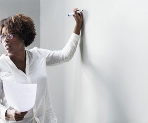 Teacher writing on the board with dry erase marker