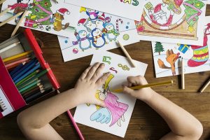 Child coloring with colored pencils