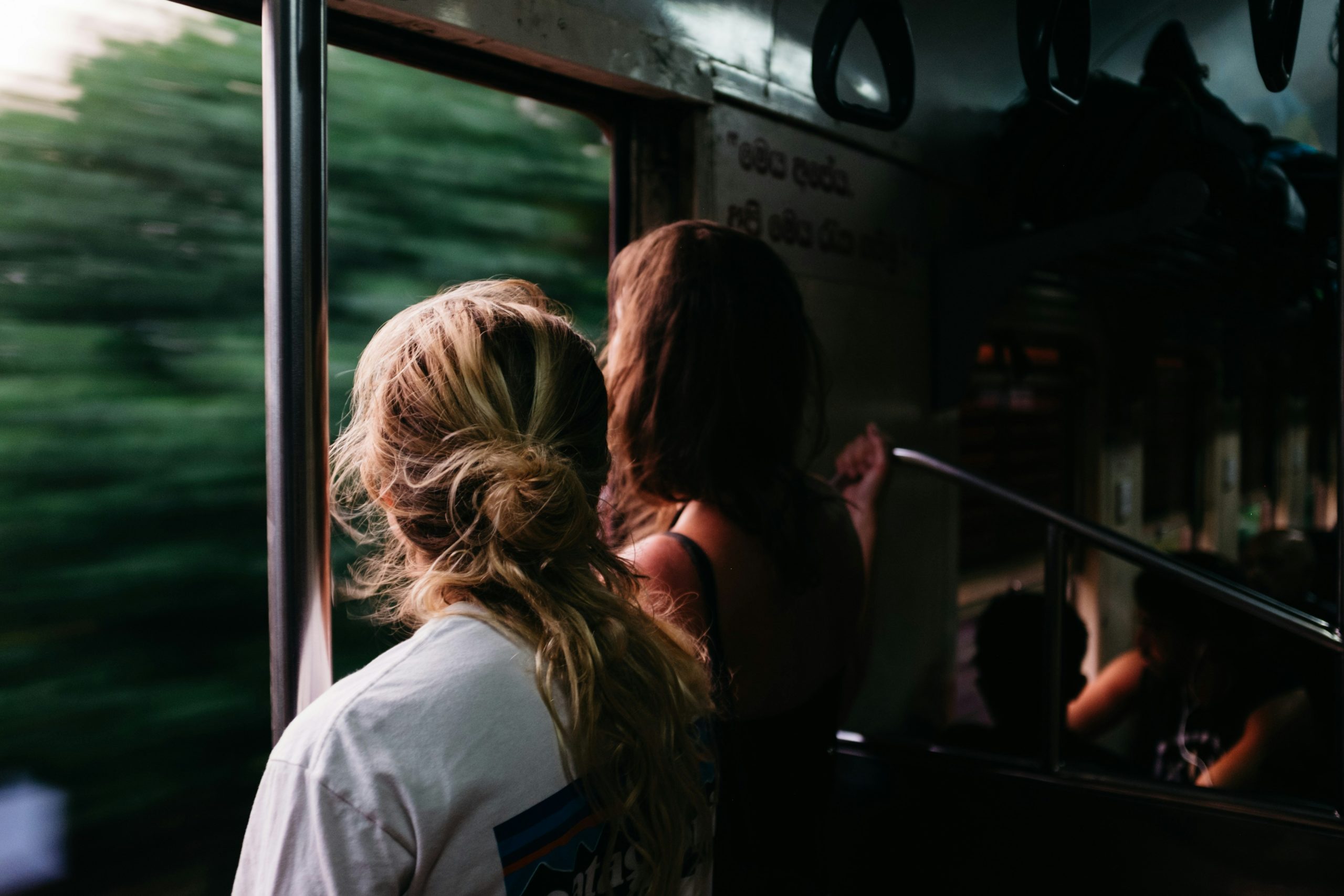 Two people looking out the window of a moving train, exploring something new.