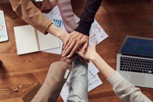 A team puts their hands together in a sign of unity.